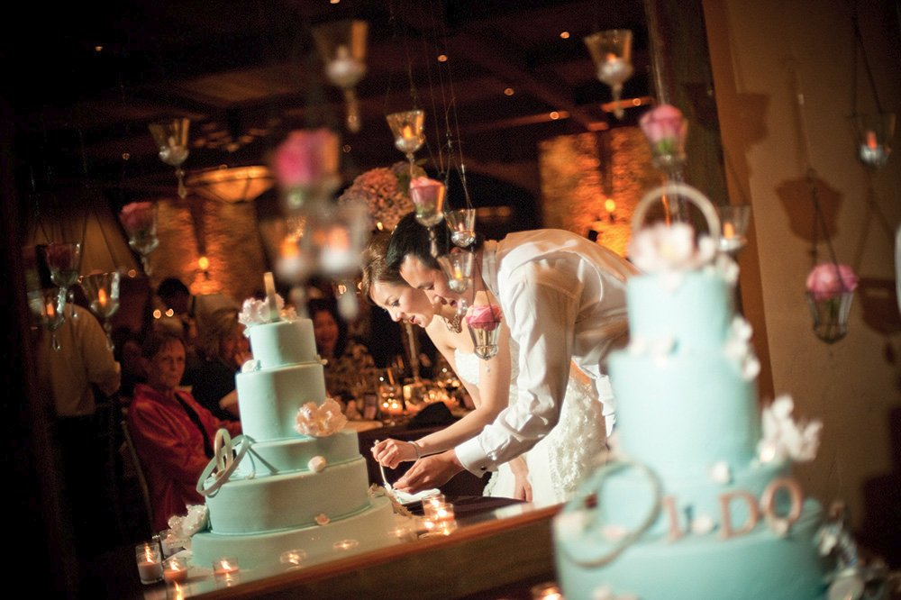 Asian couple at ceremonial cake cutting