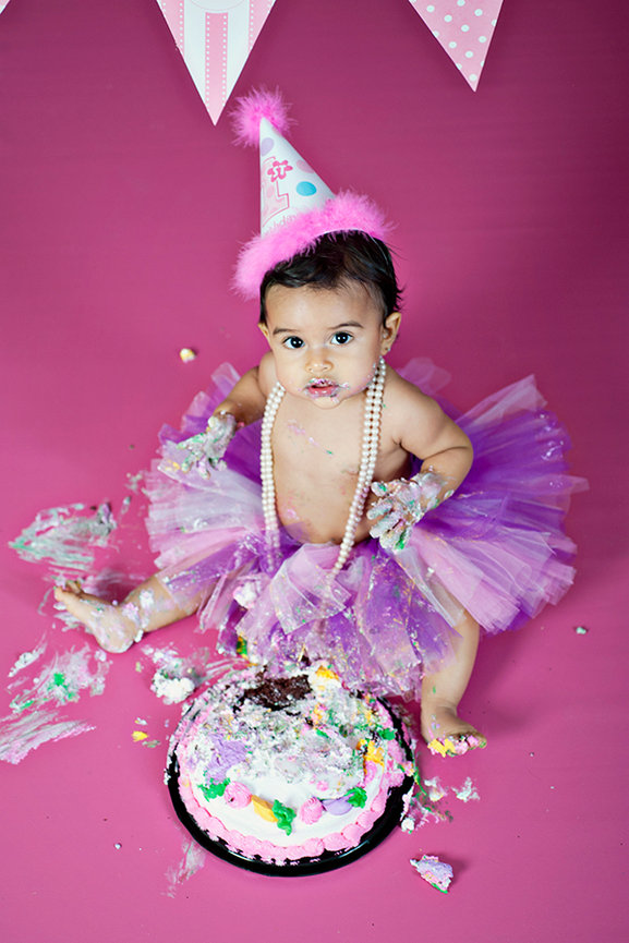 Niña con un pastel de cumpleaños, sesión de fotos de bebé de 1 año