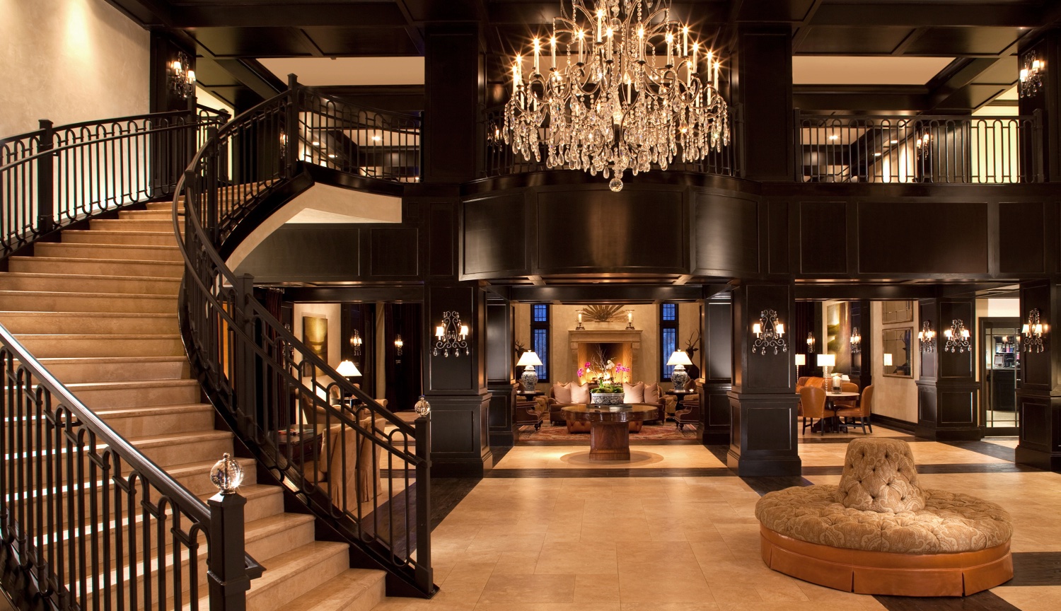 Waldorf Hotel Lobby in PArk City Utah with Winding Staircase, large Chandelier leading to fireplace and beautiful seating area.