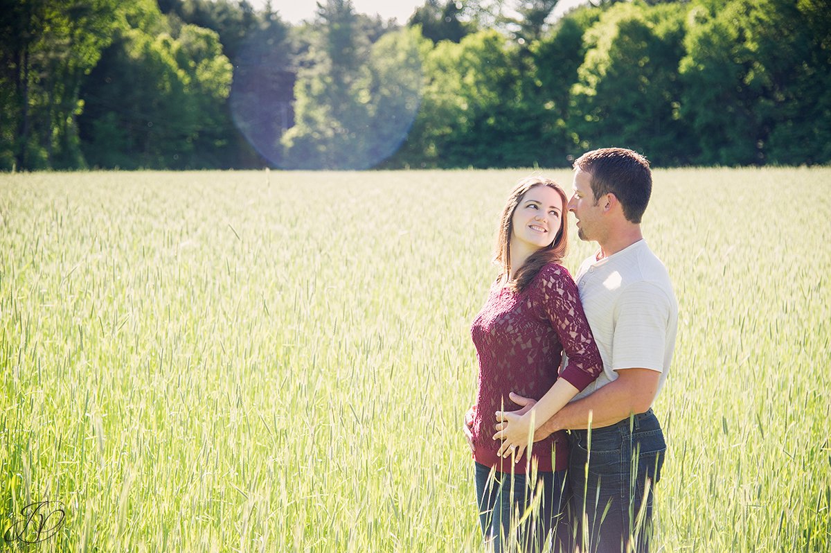 romantic photo of couple in a field with sun flair