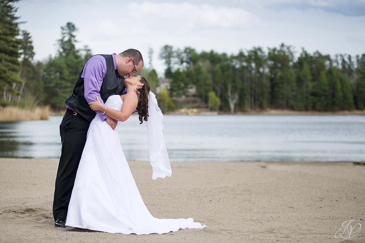 photo of groom dipping bride on the beach