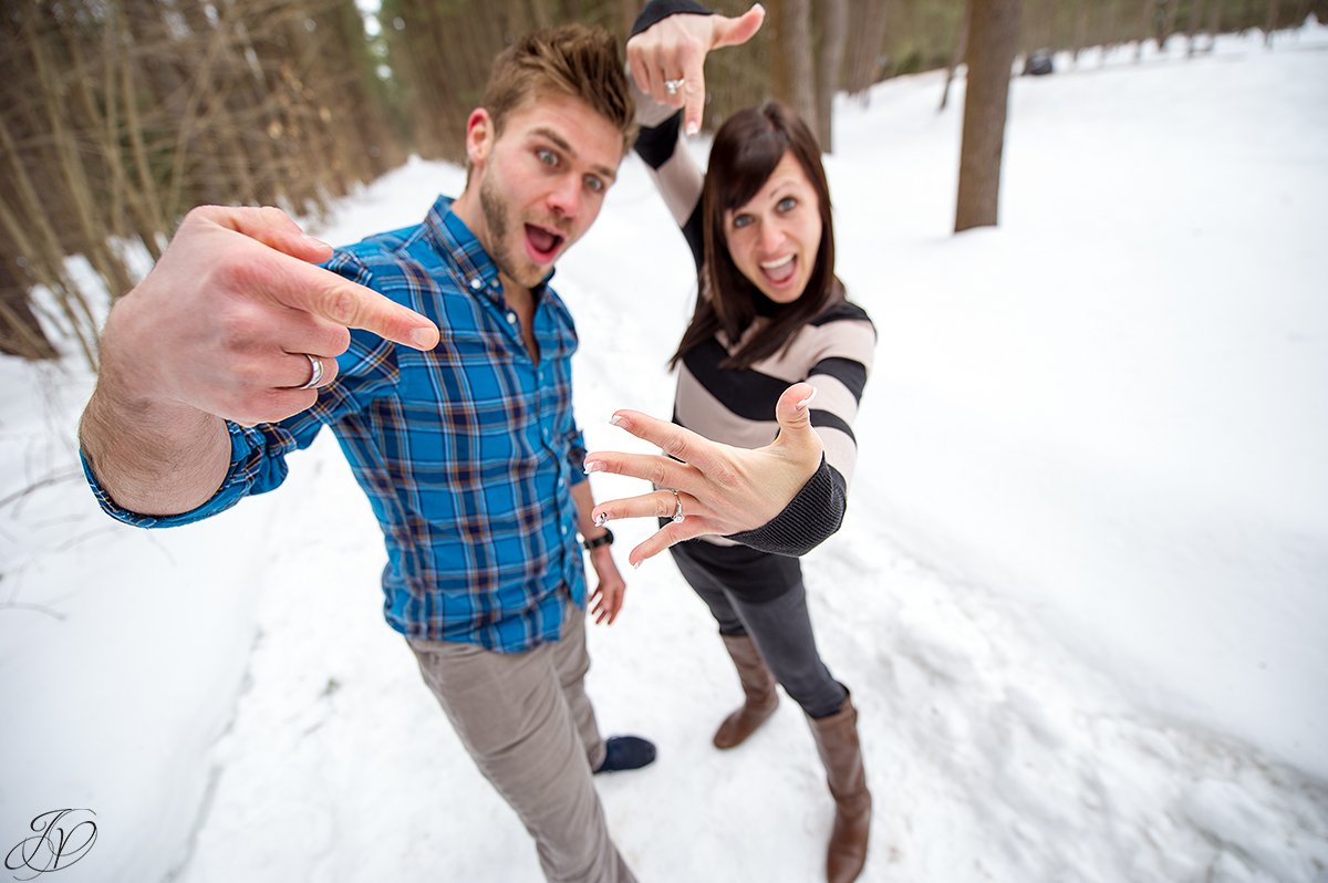 silly photo of engaged couple showing off the bling