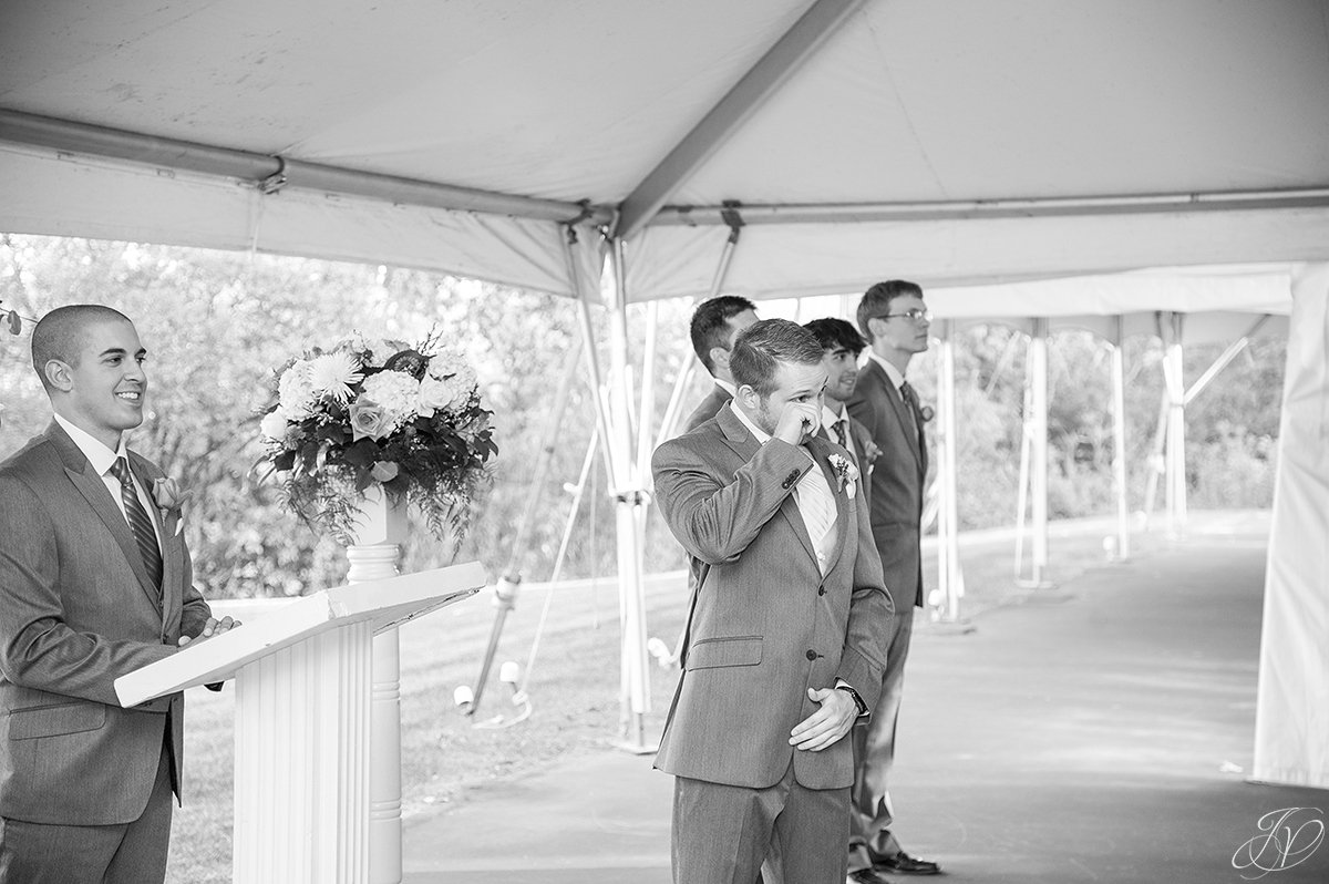 groom wiping away tears during ceremony