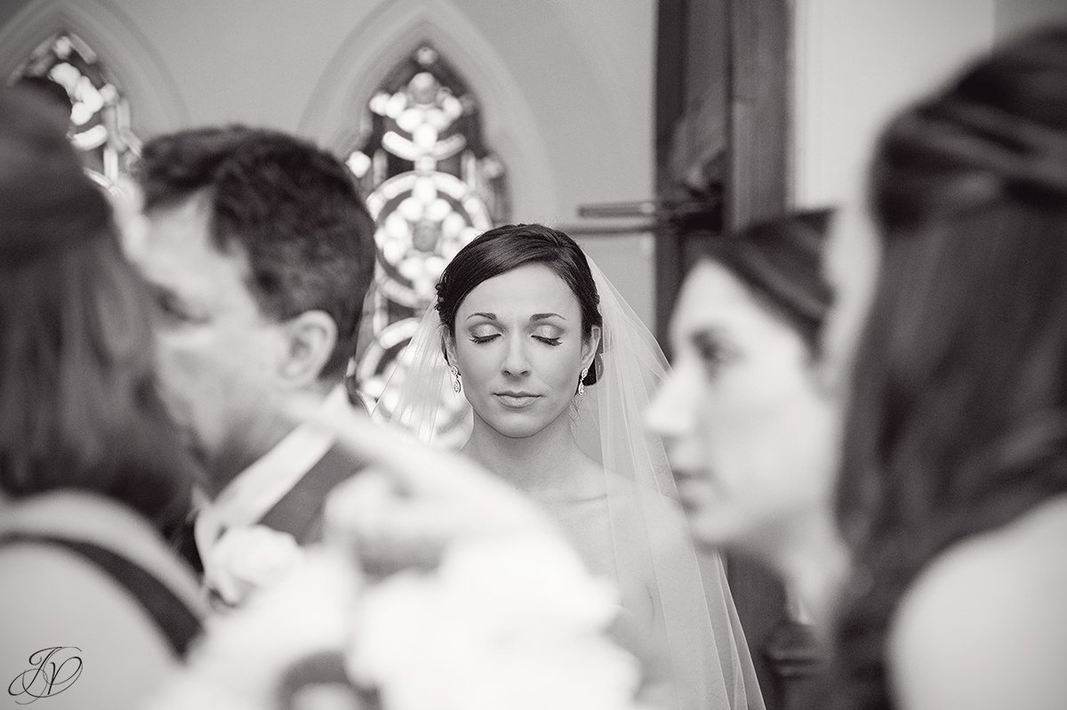 unique black and white photo of bride taking moment before ceremony