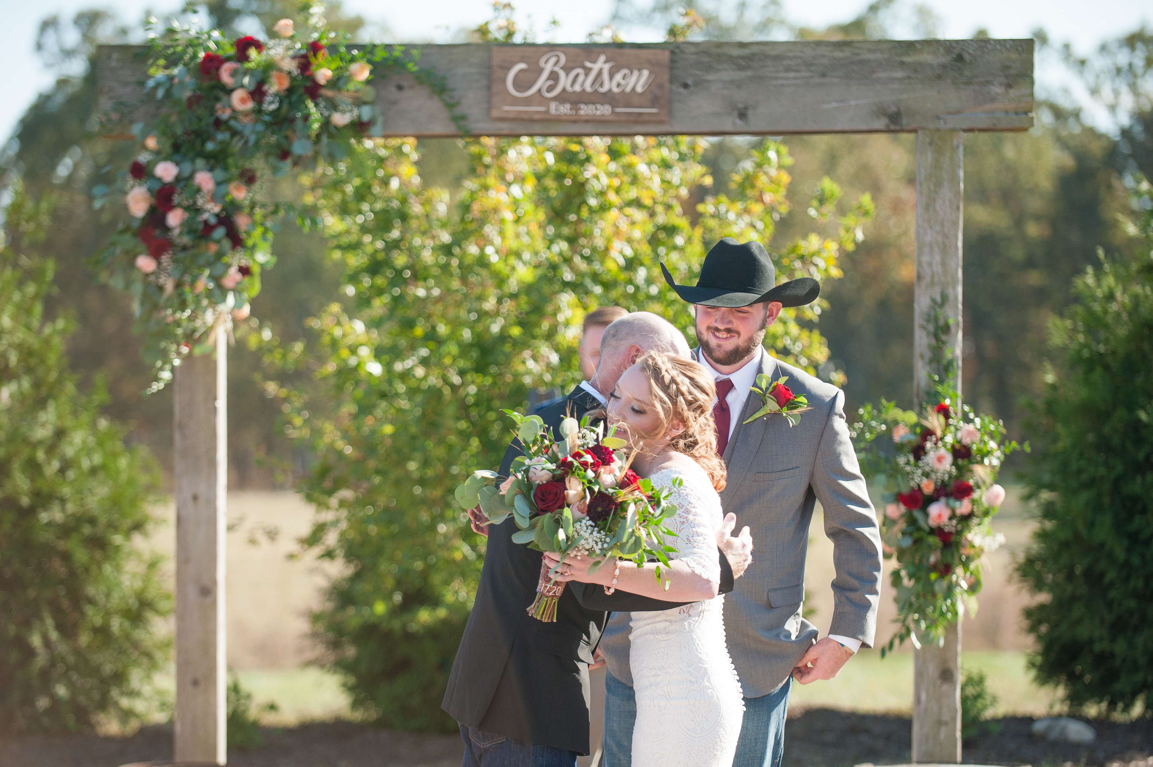 Father handing his daughter off to the groom after walking her down the aisle.