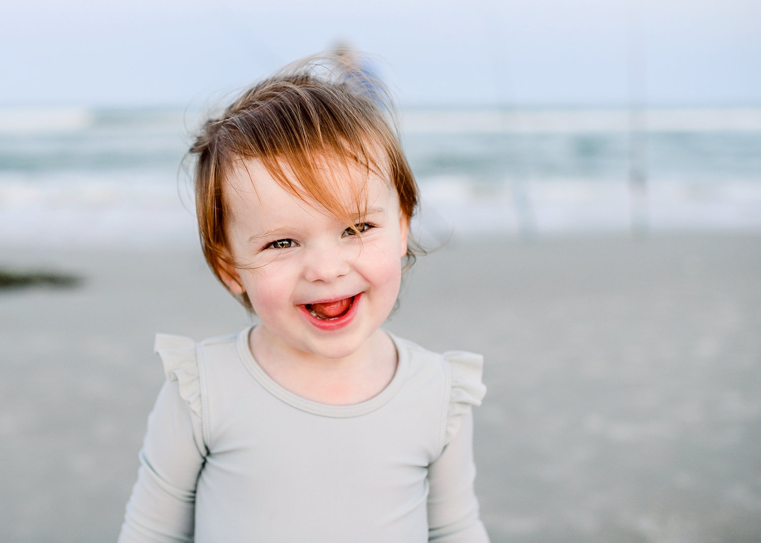 toddler girl smiling at the camera, Florida beach in the background, Ryaphotos