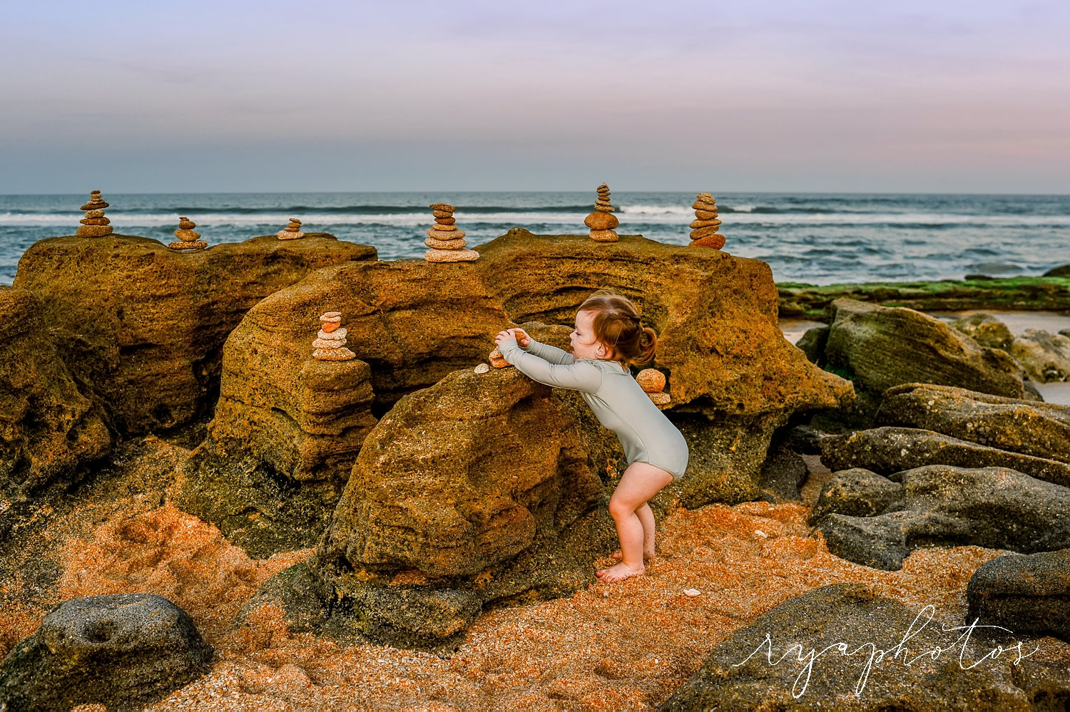 little girl stacking rocks on a Florida beach, rocky Florida beaches, Ryaphotos