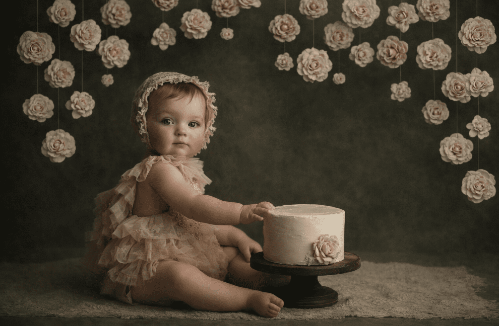 Fine art heirloom portrait of baby with cake in studio with floral by Austin portrait photographer Texas Vogue Photography.