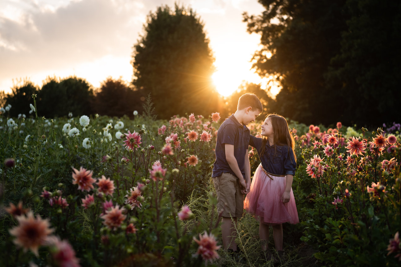 brother and sister look at each other in dahlia flower field clarkston mi