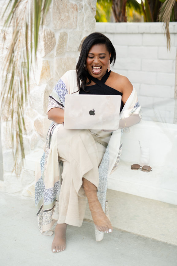 small business owner laughs at camera outdoor headshot with laptop