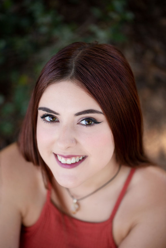Senior girl wearing a red top posing for her senior images