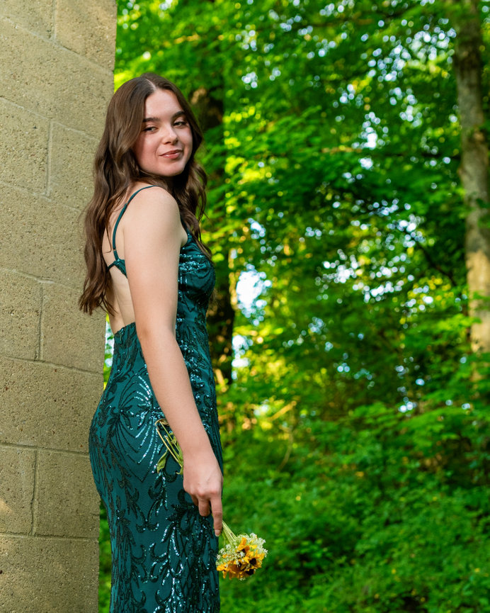 senior girl in a sparkly green long prom dress