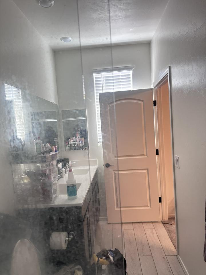 Before deep cleaning: Las Vegas shower glass with cloudy hard-water and soap-scum buildup