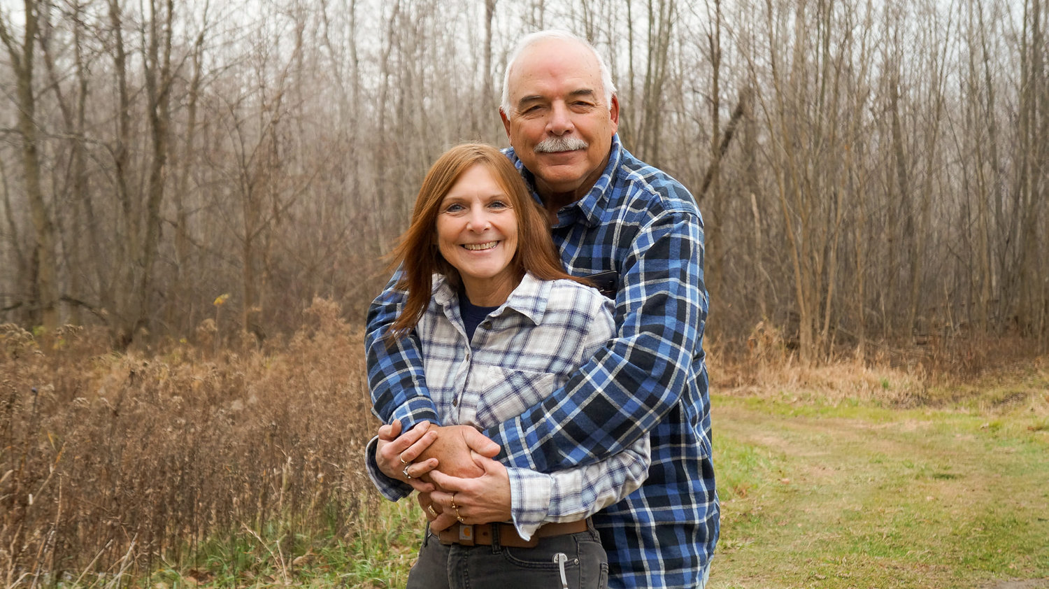 Older couple hugging in a field