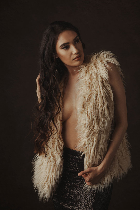 Elegant and sexy picture taken in studio showcasing a fancy furry coat and long brown hair, taken in a photo studio with Adam Trujillo, a Las Vegas portrait photographer.