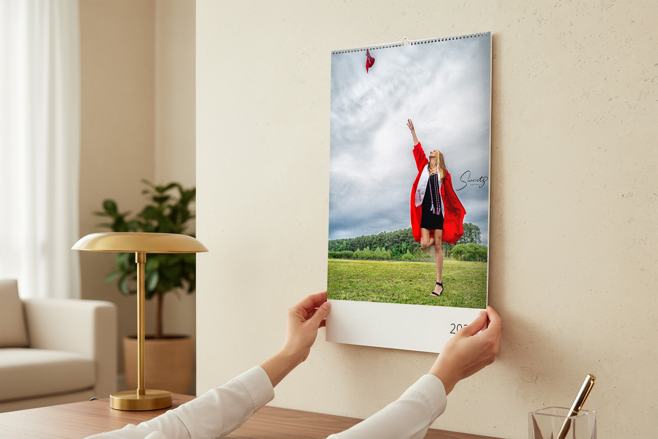 Gallery canvas senior portrait being hung on a living room wall, the kind of heirloom a referral earns, by Swartz Portraits