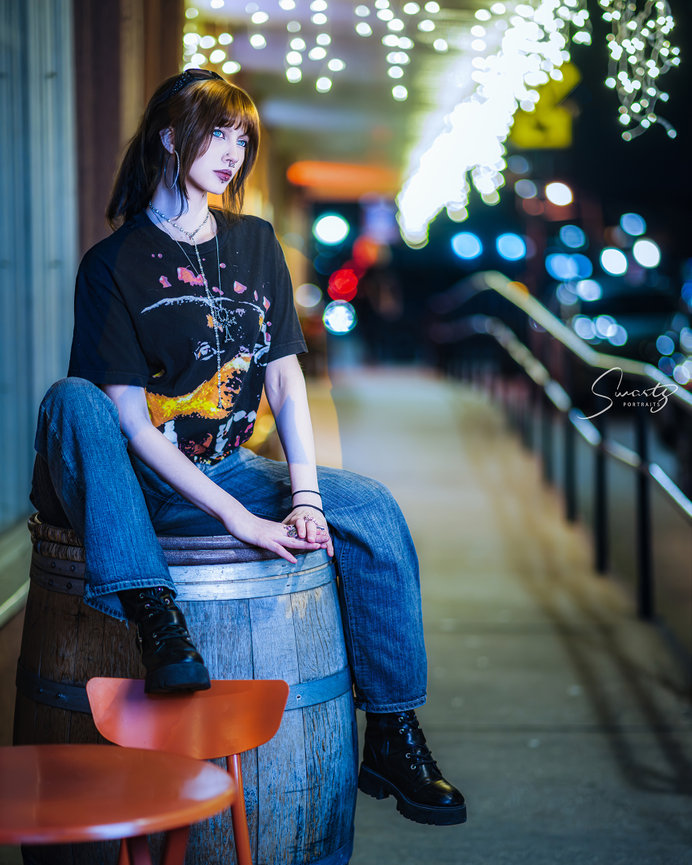 Senior portrait on rustic barrel with twinkle lights, intimate evening fine art by Swartz Portraits Texas