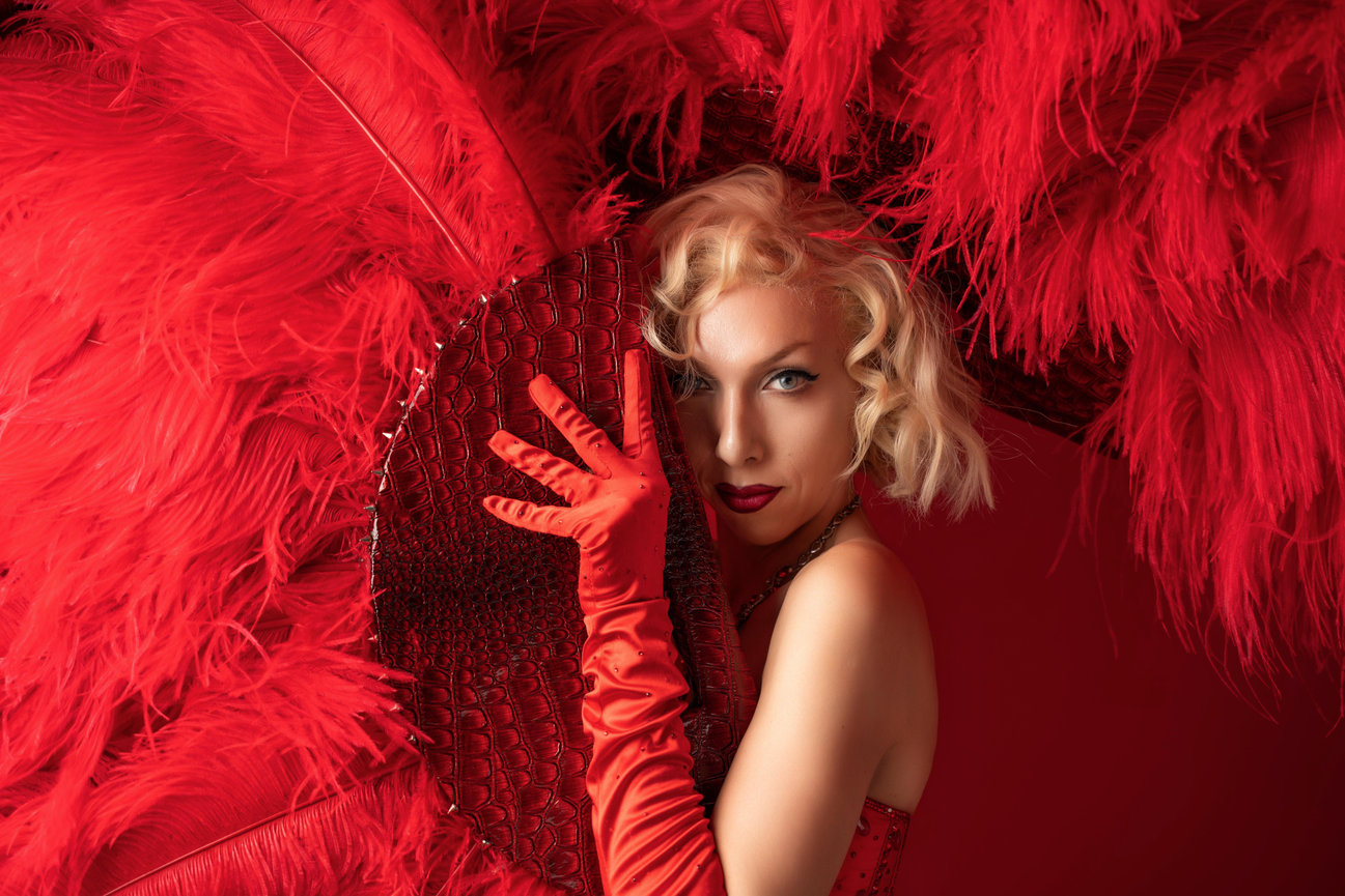 Woman in red with dramatic burlesque red feather fan.