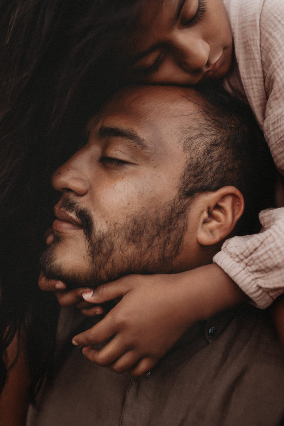 A young girl resting her head on her father during their family photo session in New Jersey.