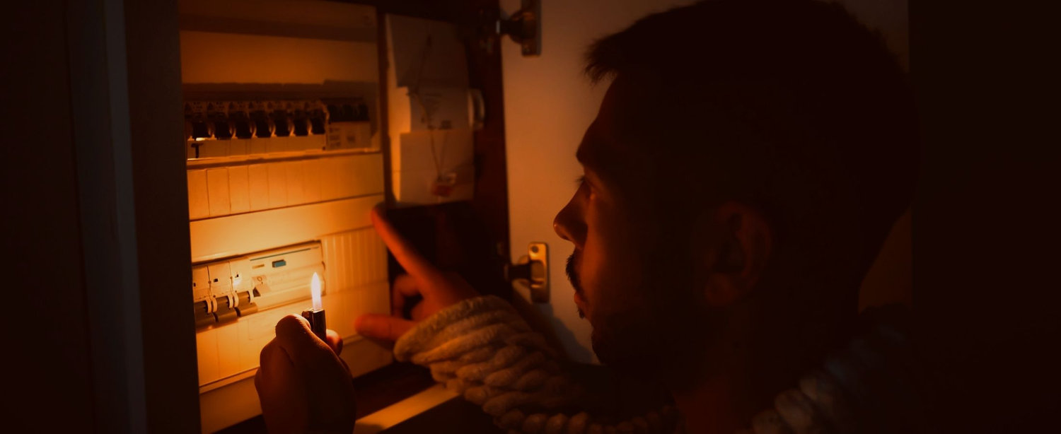 A consumers using a lighter to view their electrical panel in the dark is used as a background image behind some text that is a testimonial for a client that has worked with Russ Bell as a consultant