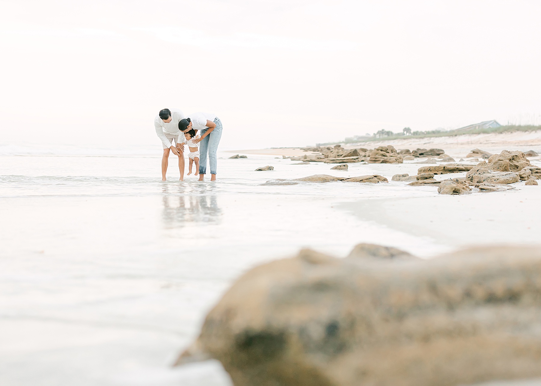family standing on beach out of focus