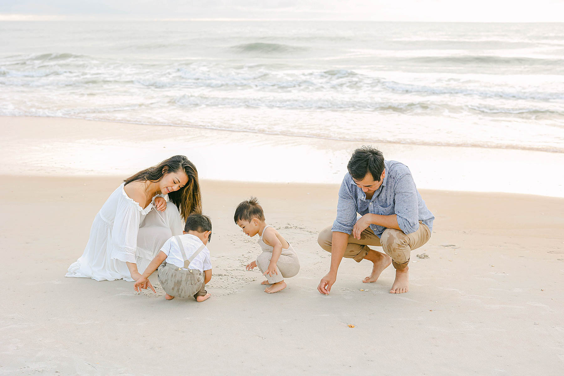 family kneeling down at the beach 