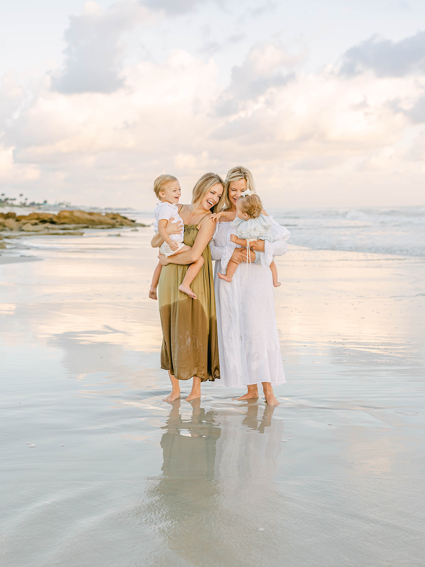 women holding children at the beach at sunrise in florida