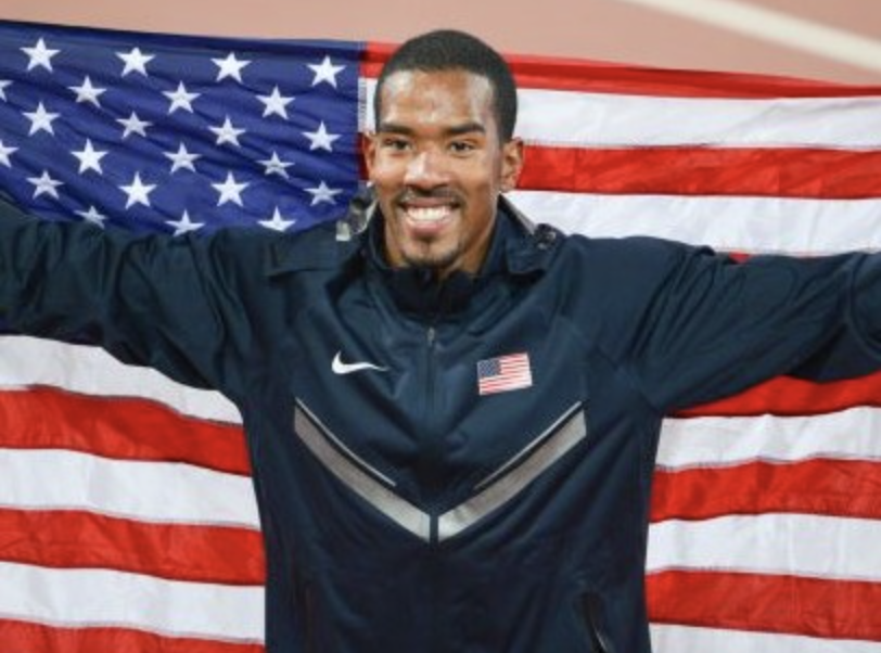 christian taylor holding an american flag at the olympics
