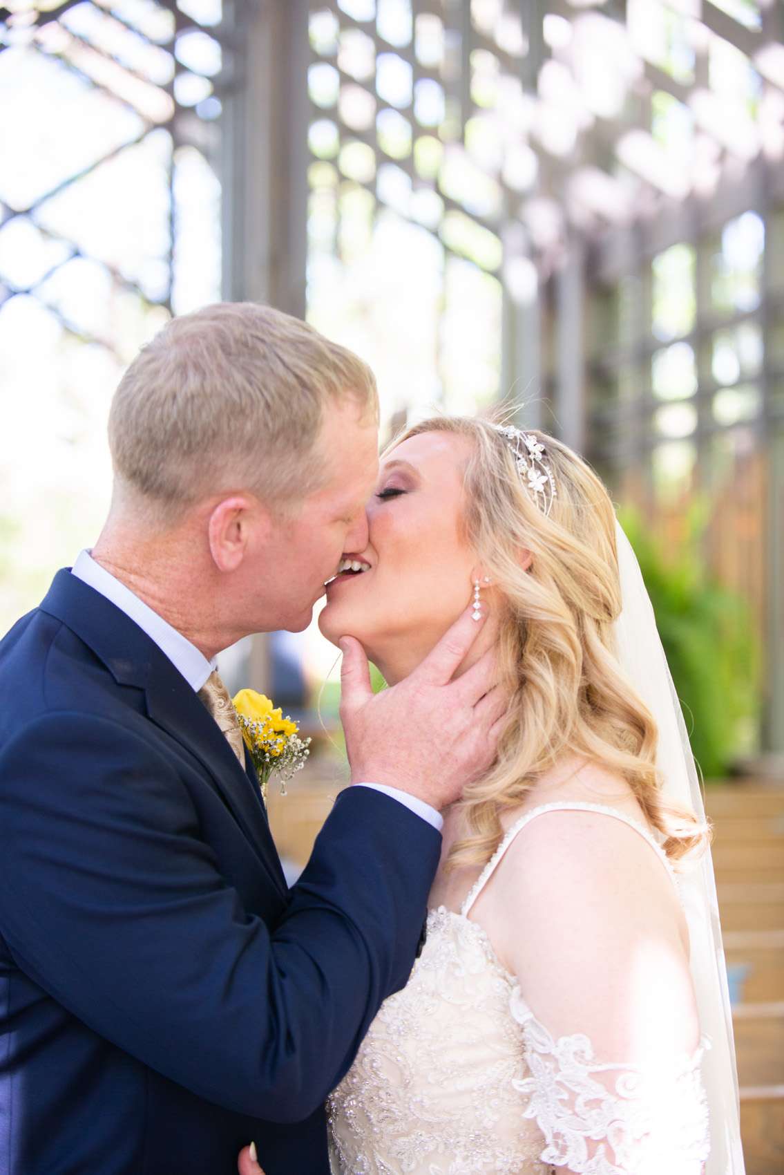 Wedding couple kissing for photos after ceremony