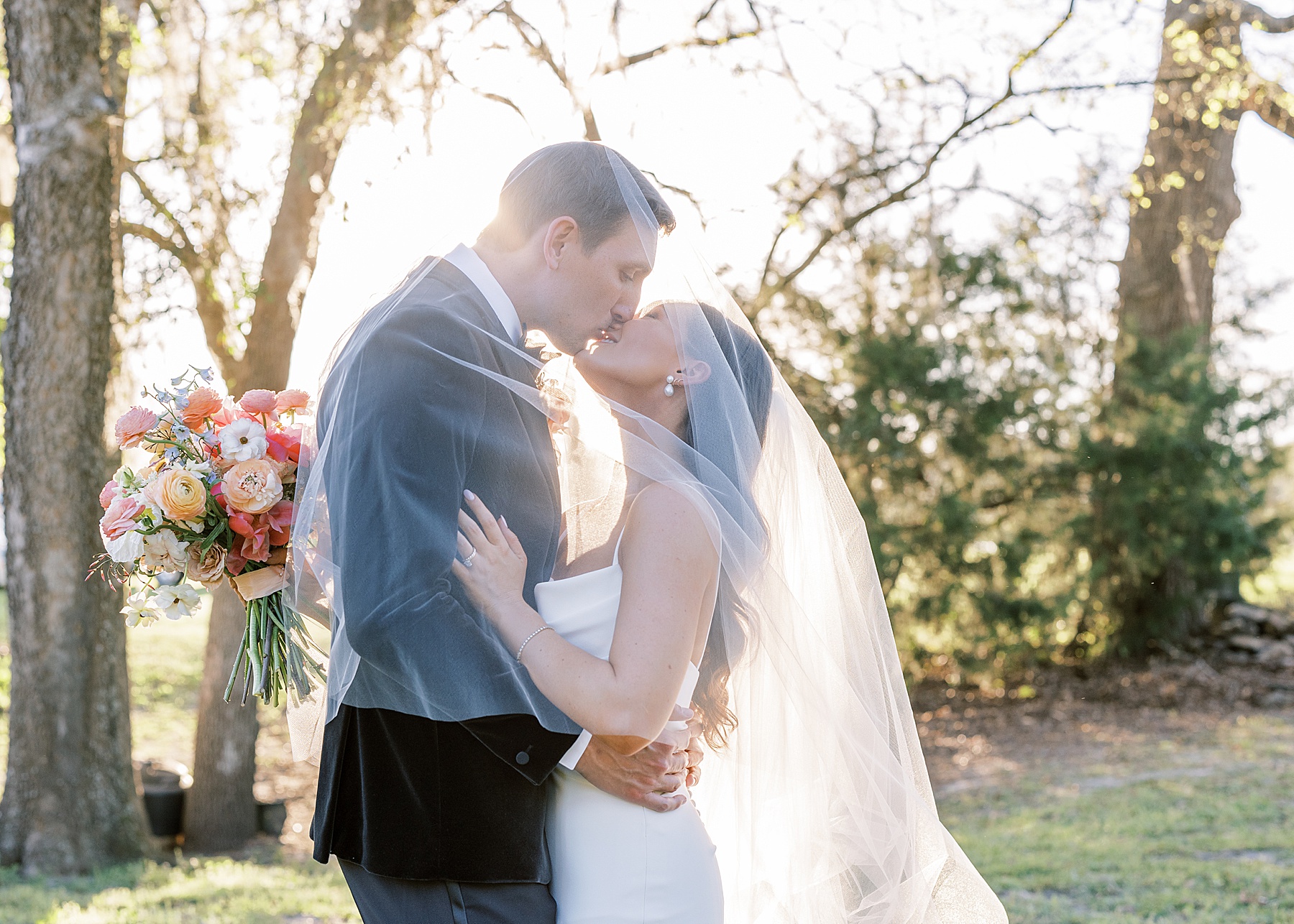 man and woman kissing under bridal veil at private estate in Jacksonville florida