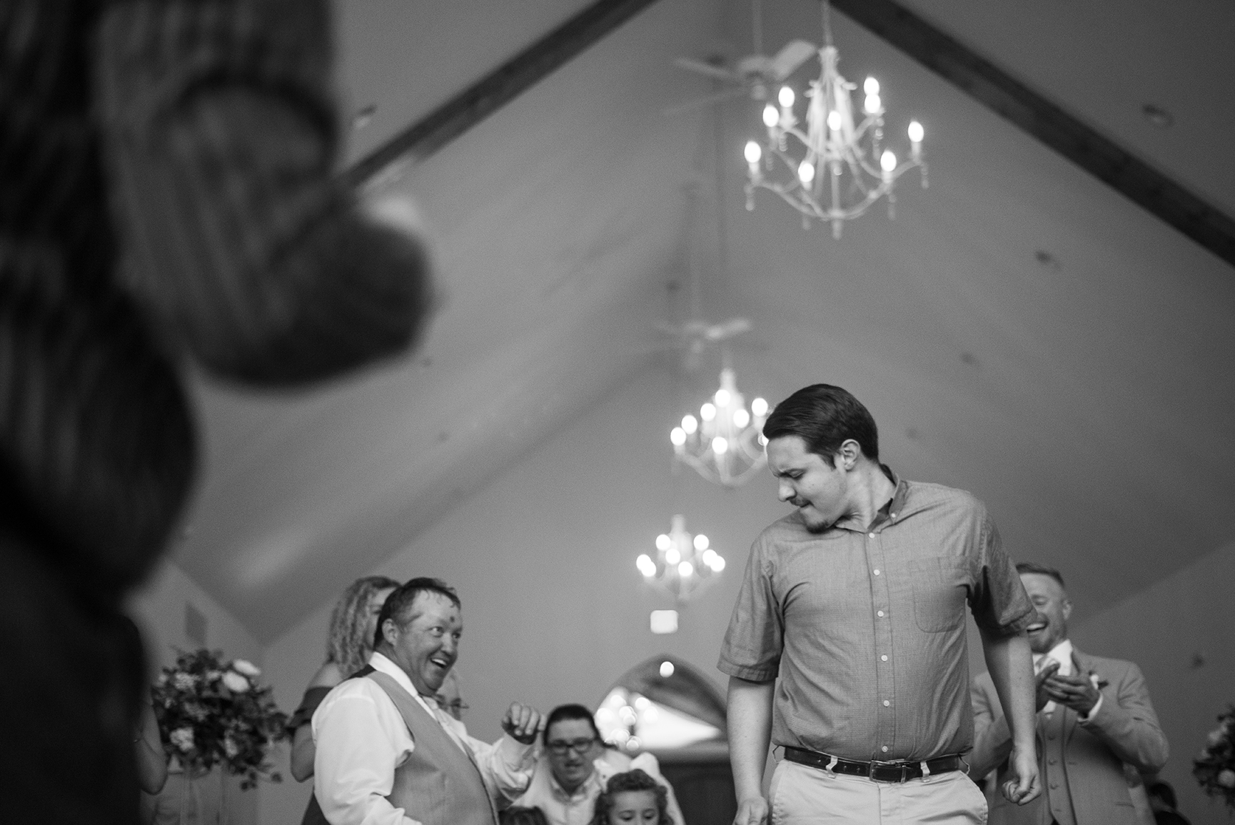 Father of the groom watching another guest dance at the reception near Table Rock Lake.