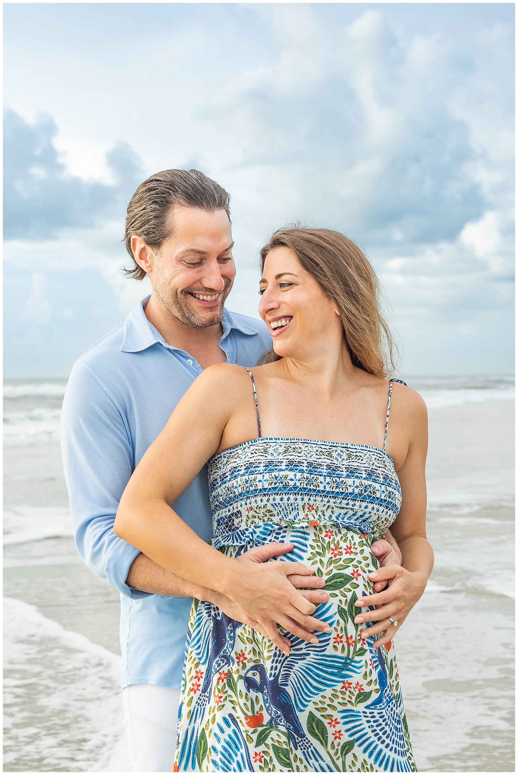 man and pregnant woman holding each other on the beach during an airy sunrise in st. augustine beach florida