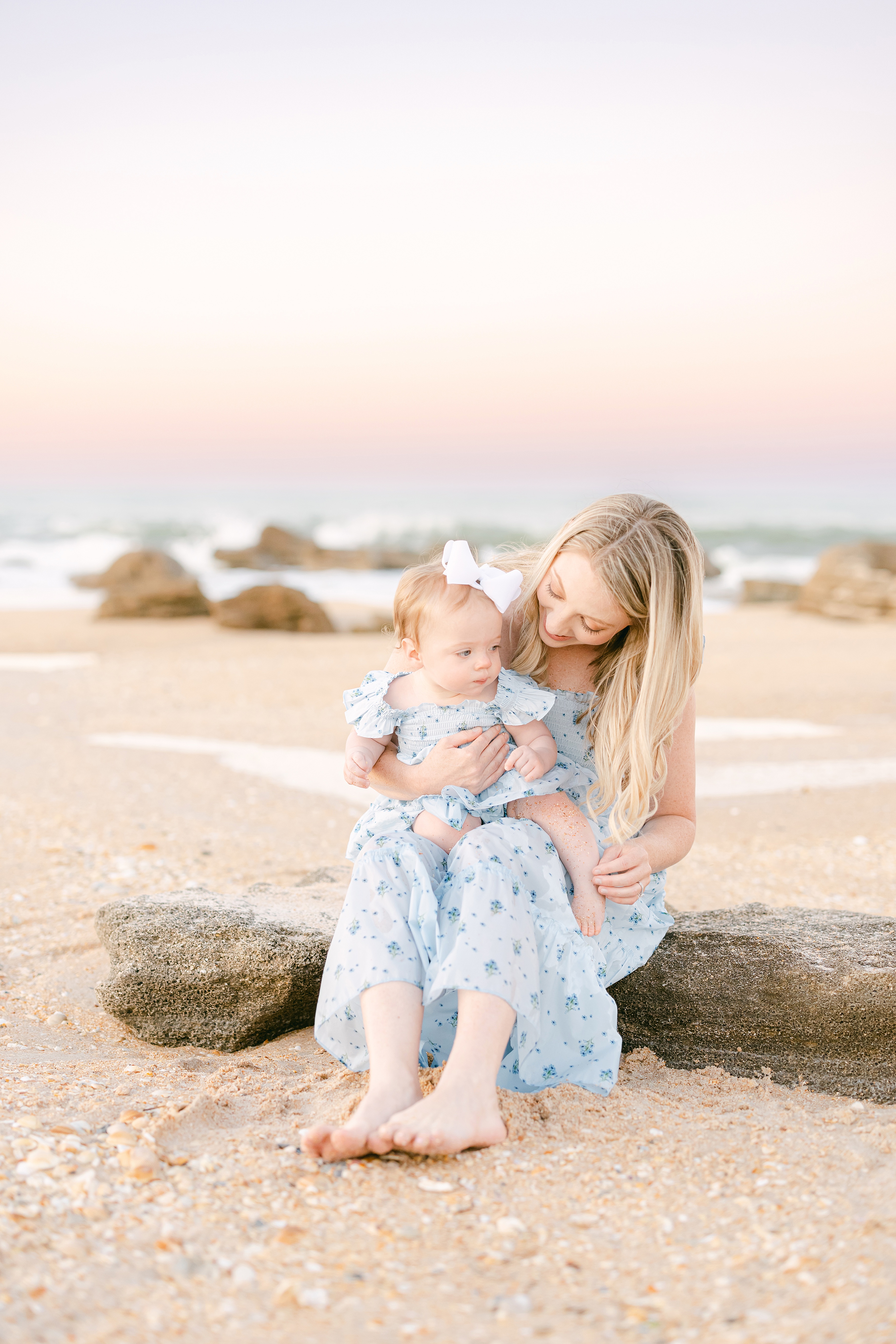 pastel sunset beach portrait of woman and baby girl in pale blue dresses