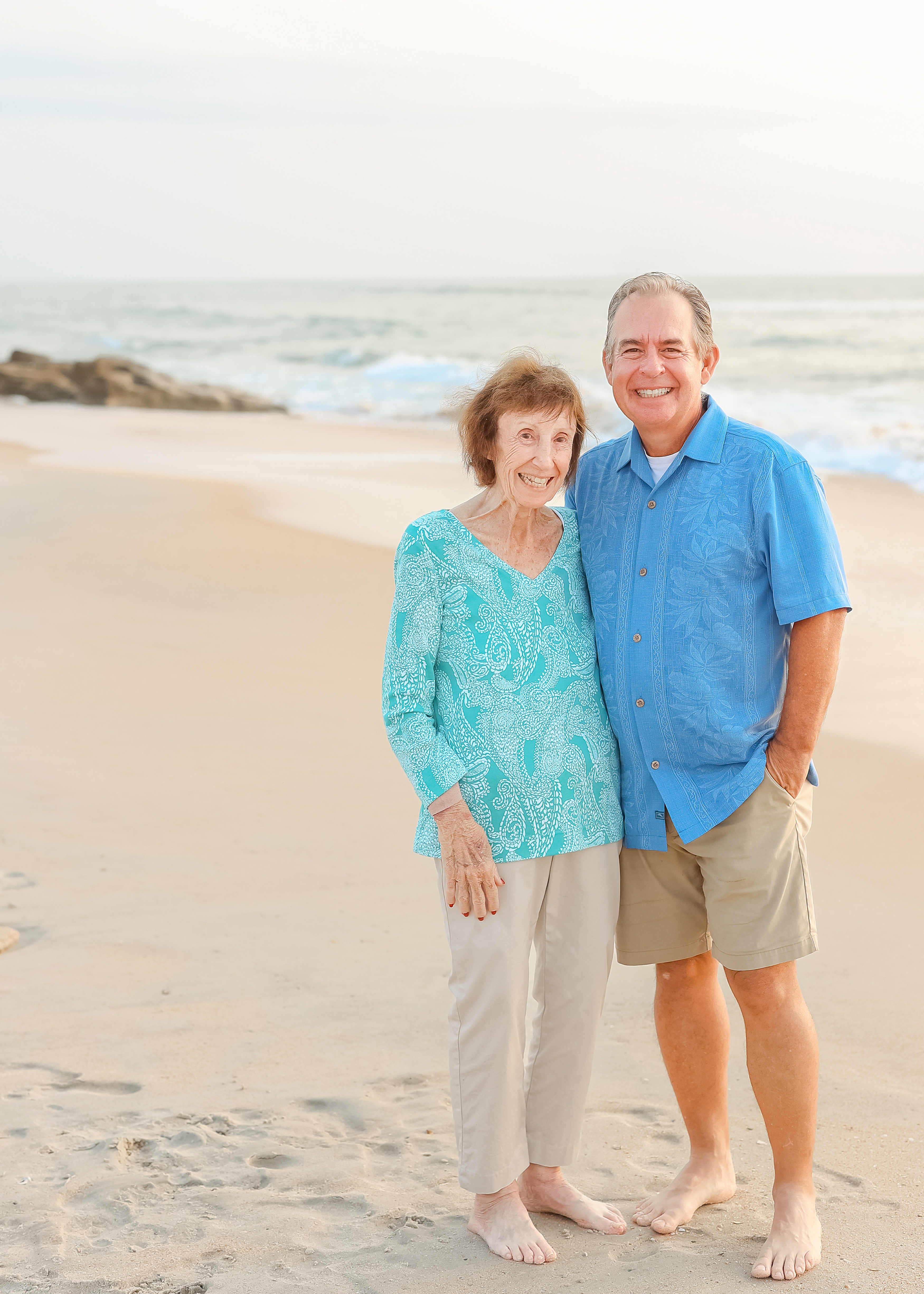 a old man and his mother standing on the beach at sunrise in Florida