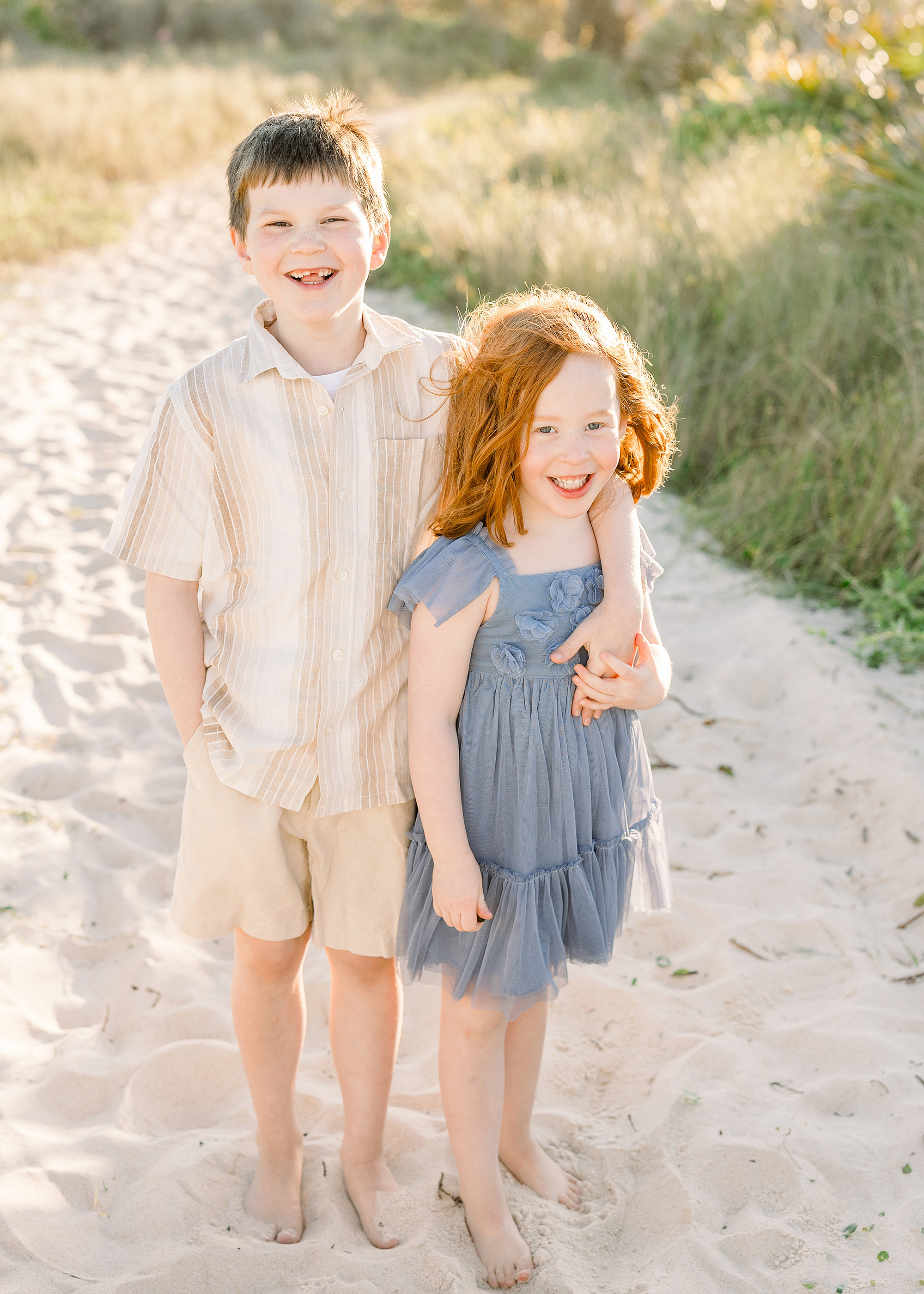 Two siblings stand next to each other at sunset on Saint Augustine Beach.