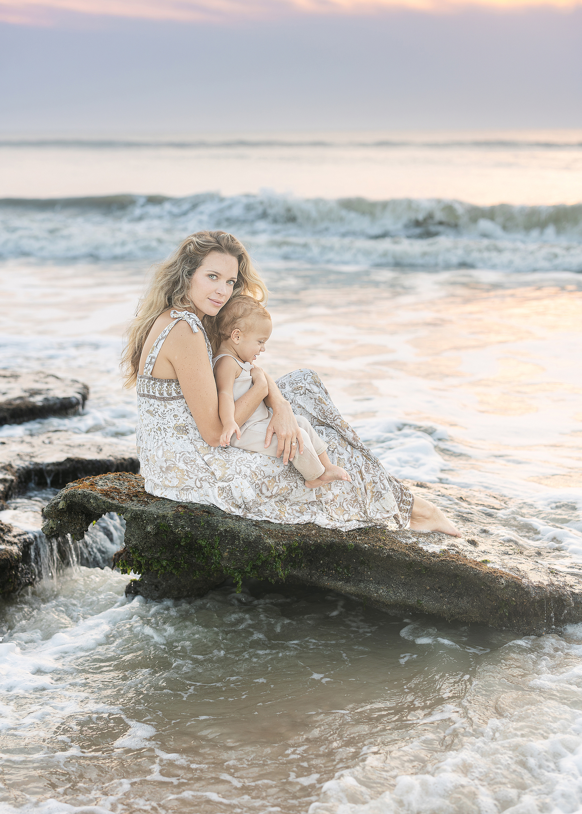 A motherhood portrait of a woman and her one year old baby boy at sunrise on the beach in St. Augustine.