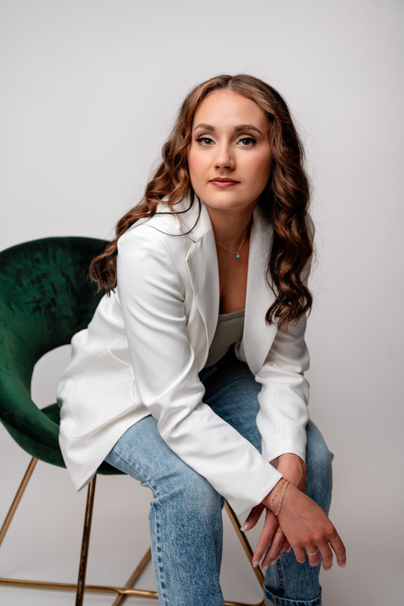 Business woman sitting in a green velvet chair on a white backdrop, branding photographer la crosse wi
