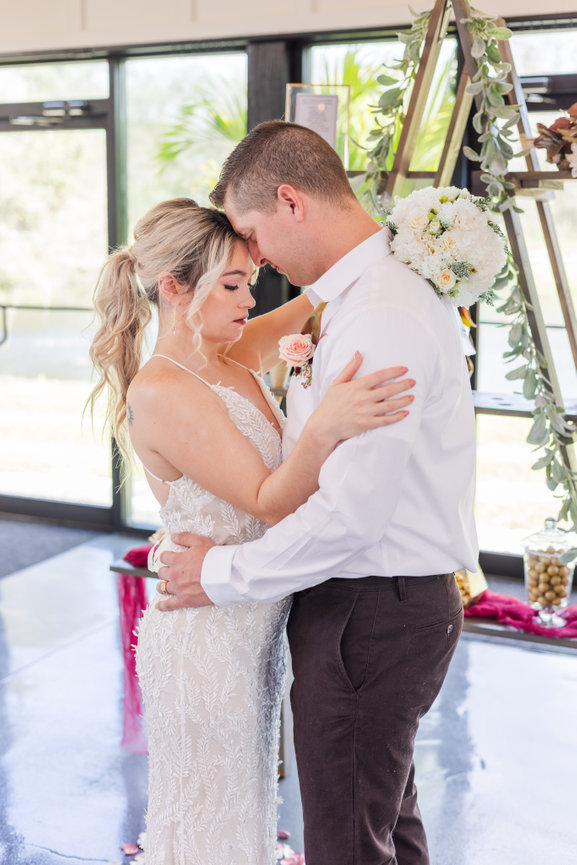 Bride and groom embrace, touching foreheads at SoireEstate.