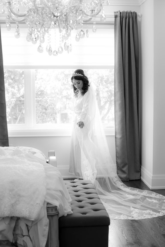 Bride standing near a window in a wedding gown