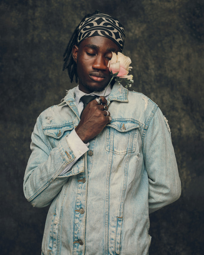 Man holding flower to cheek