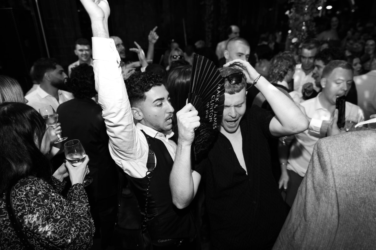 Editorial flash photography at The Refuge, Manchester; a candid, high-energy shot of wedding guests on a busy dance floor.