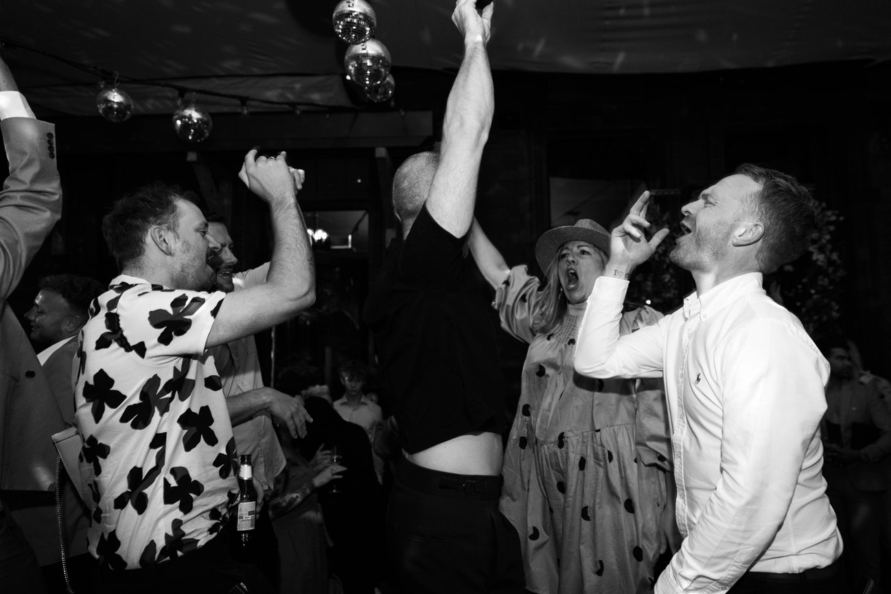 Editorial flash photography at The Refuge, Manchester; a candid, high-energy shot of wedding guests on the dance floor.