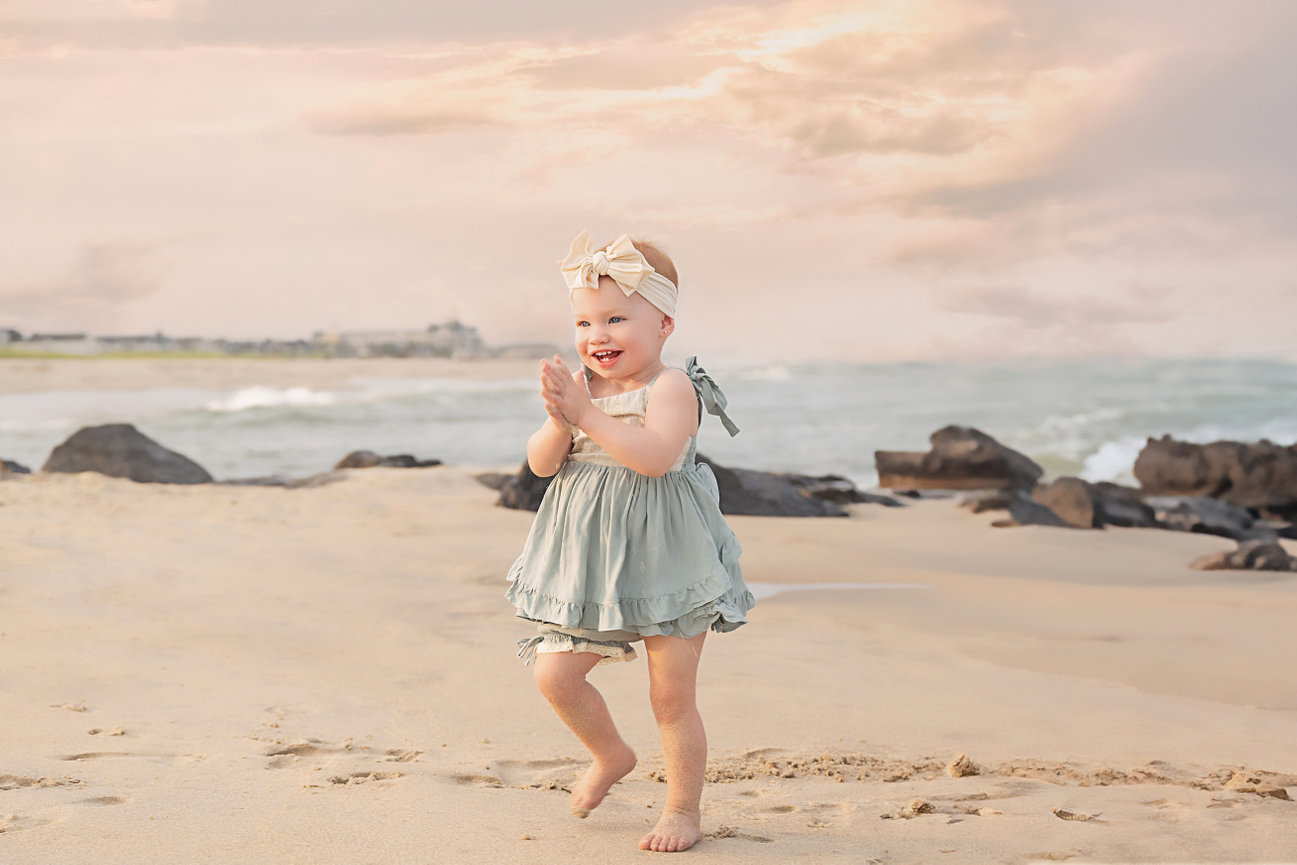 Candid image of toddler giggling mid-run across the sand