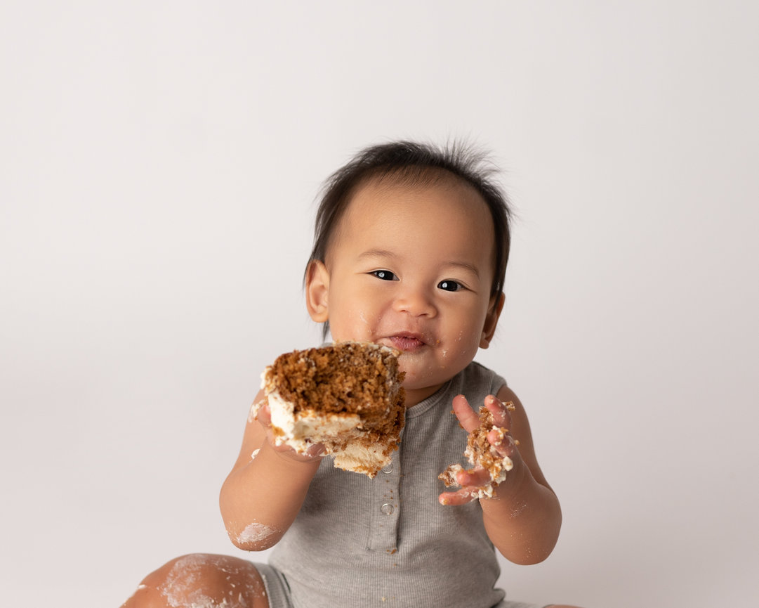 Messy cake smash with baby joyfully covered in icing in Chatham, NJ