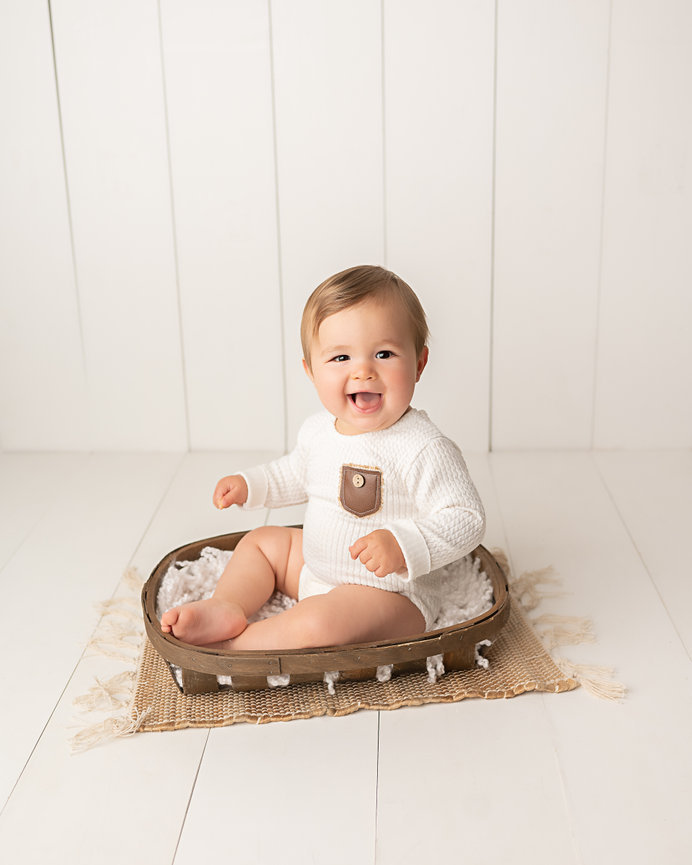 Organic milestone setup in Rumson natural light studio with baby sitting in woven basket