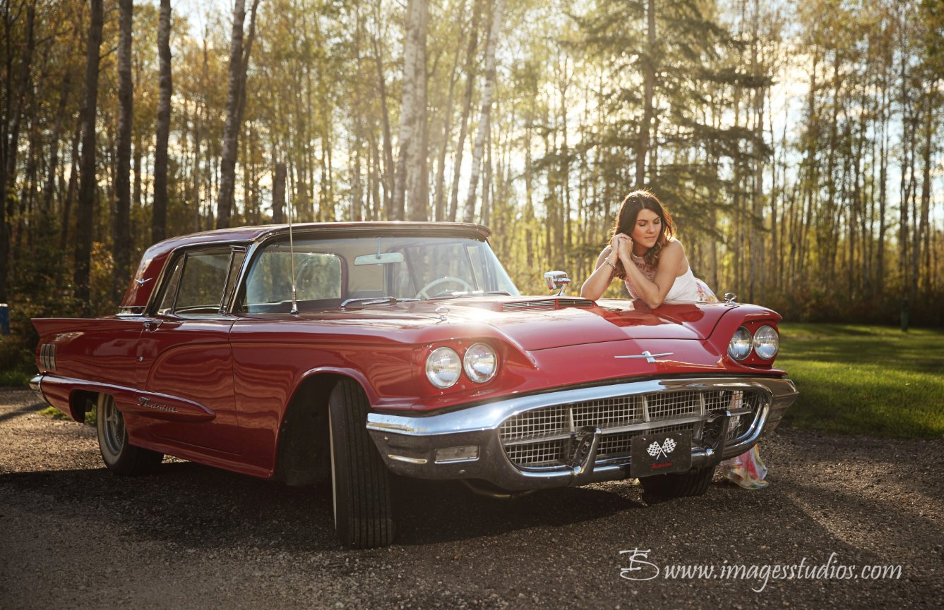 photo of a bride or grad leaning against a classic car