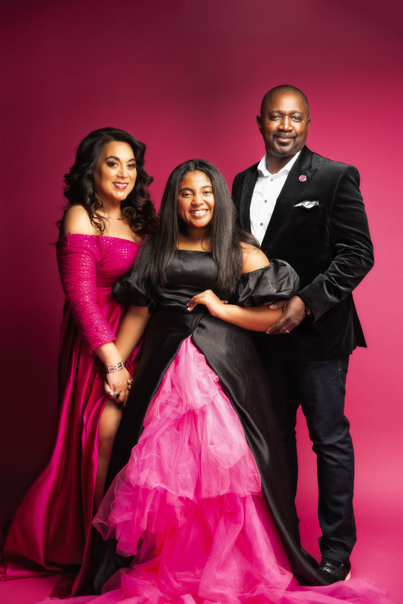 Fort Worth family portrait session in studio with parents and two daughters wearing formal outfits.
