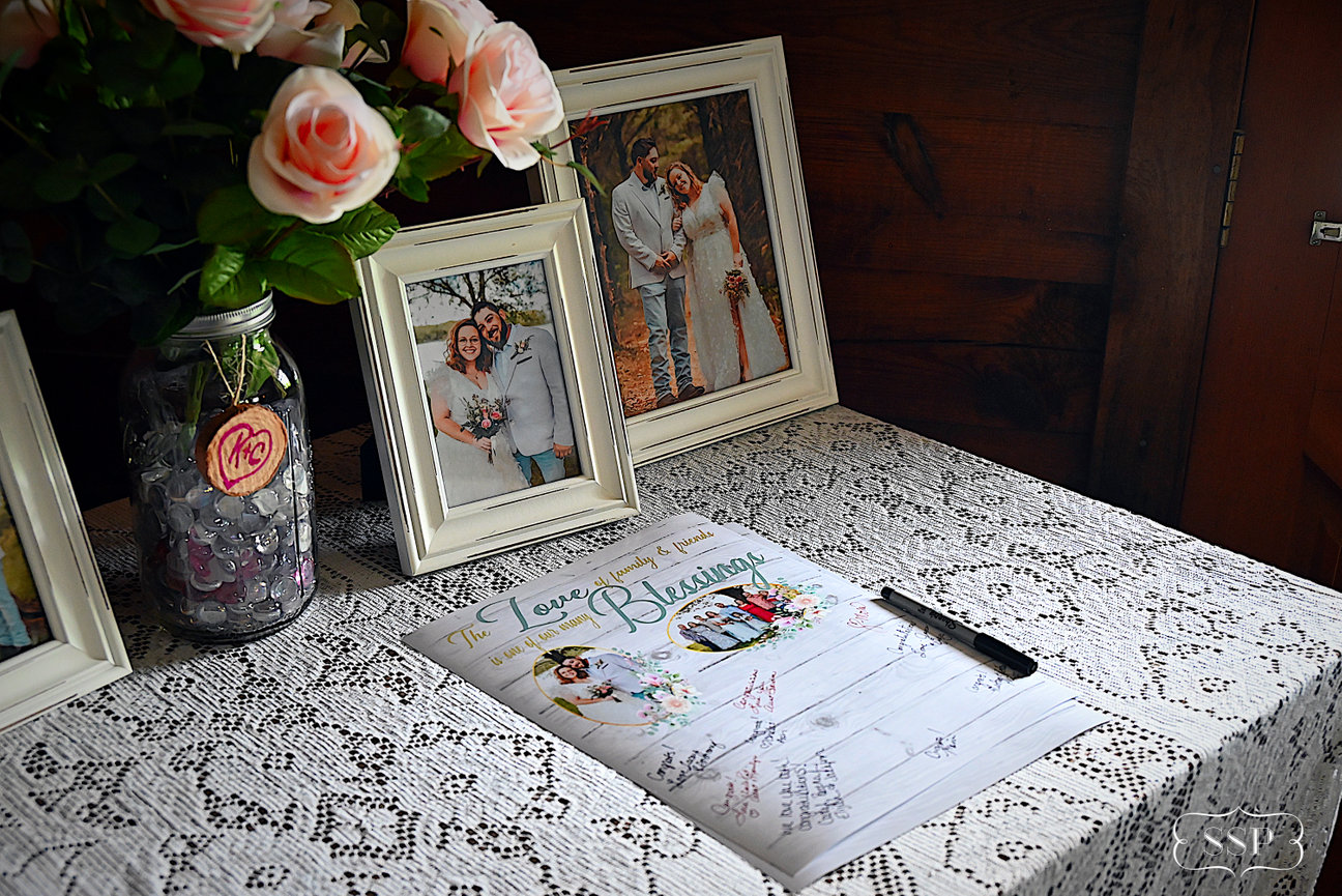 Framed photos and a guestbook displayed on a decorated table