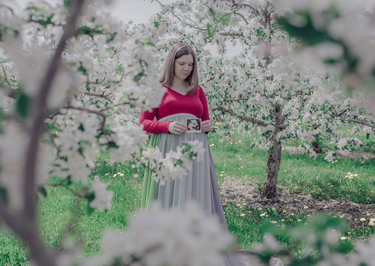 Woman standing in a field of white blossoms