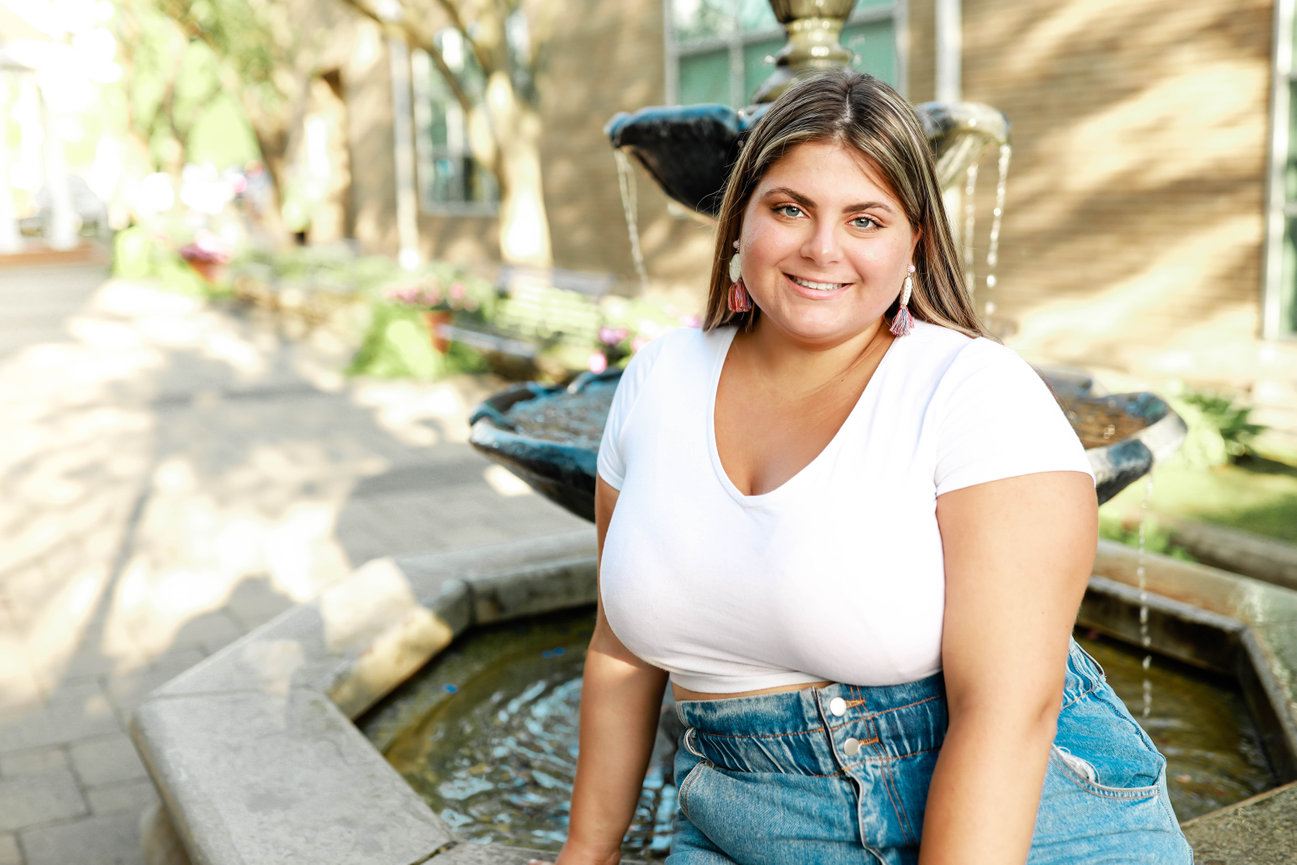High school senior girl, female portrait outdoors by fountain with casual outfit